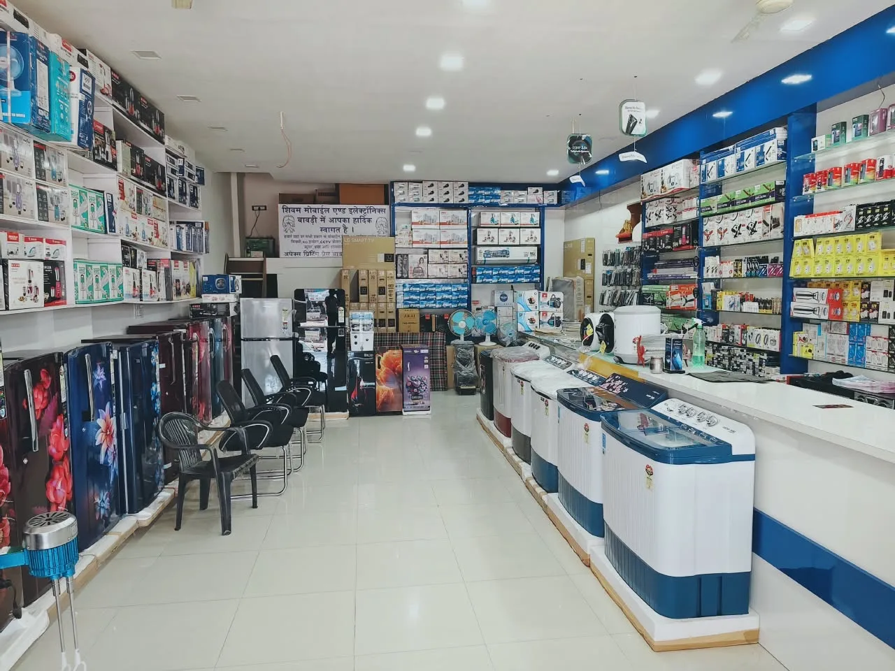 Inside the Shivam showroom with refrigerators on the left and washing machines beside the counter