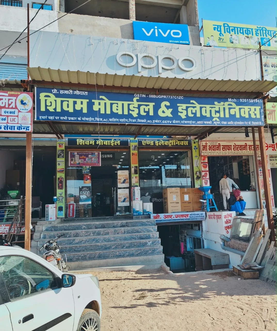 The entrance and Hindi storefront sign of Shivam Mobile & Electronics in Baori